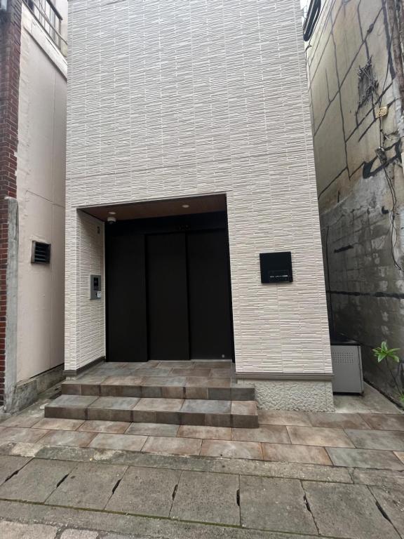 un edificio con una puerta negra a un lado. en ホテル　レヴィベース思案橋 en Nagasaki