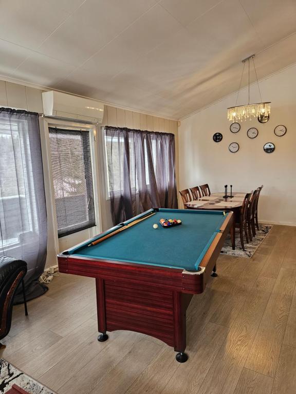 a room with a pool table and a dining room at Montana Guest House. in Lillestrøm