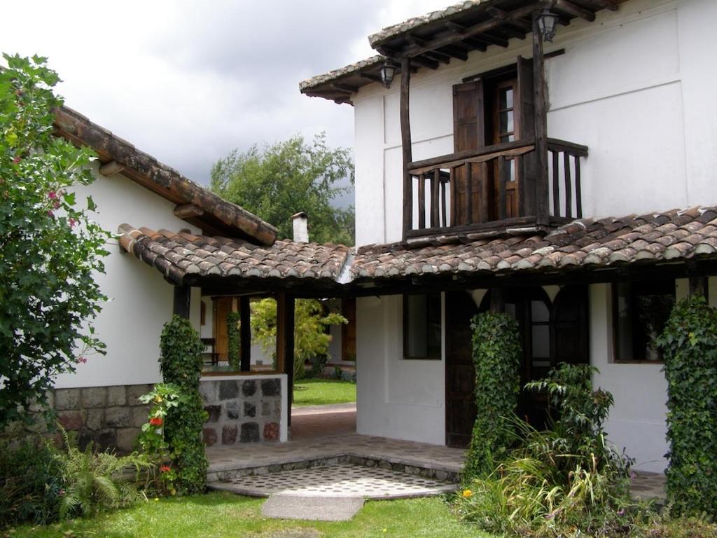 Lasso的住宿－Hostería Hotel Cuello de Luna - Cotopaxi - Country Inn，白色的房子,设有门廊和窗户