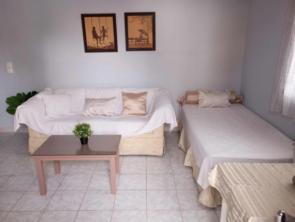 Sala de estar con 2 camas y mesa en BLE apartments, en Iräon