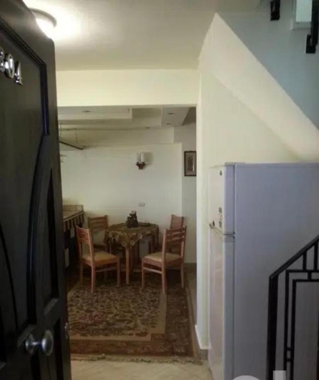 uma sala de jantar com uma mesa e cadeiras e um frigorífico em دوبلكس مفروش ومجهز em Sharm el Sheikh