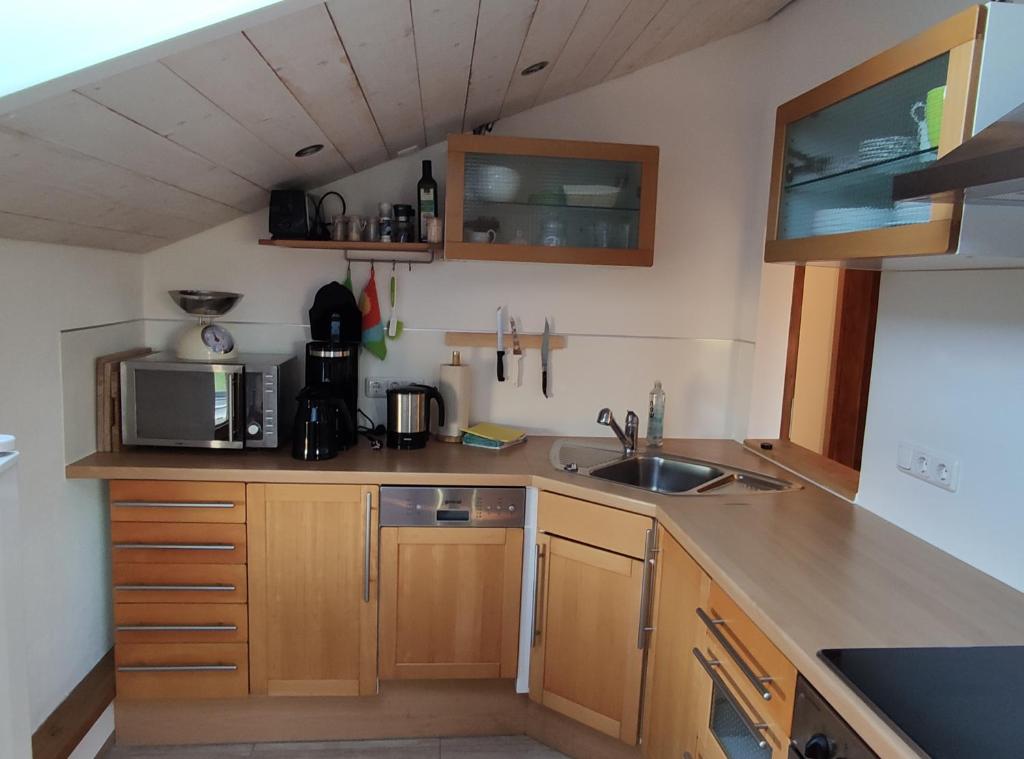 eine kleine Küche mit einer Spüle und einer Mikrowelle in der Unterkunft Ferienwohnung auf dem Land in Tuntenhausen