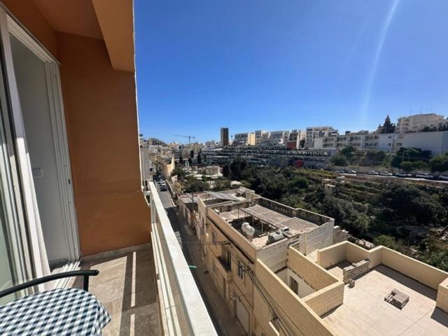 a balcony of a building with a view of a city at La Bella Guesthouse in St. Julianʼs