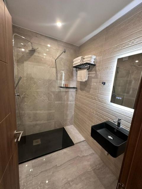 a bathroom with a shower and a sink at La Bella Guesthouse in St. Julianʼs