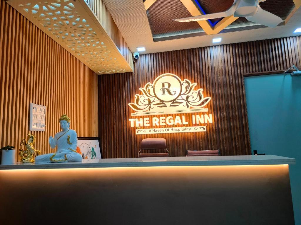 uma placa que diz a verdadeira pousada num quarto em The Regal Inn em Gorakhpur