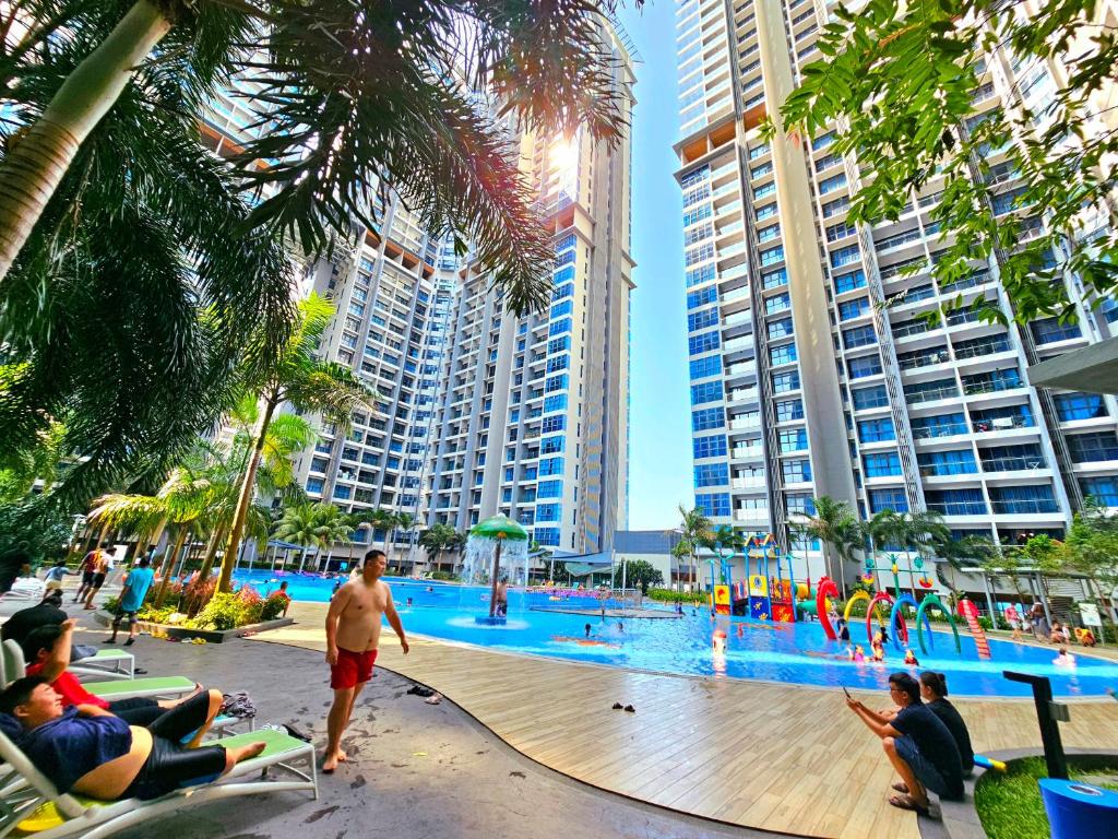 un gruppo di persone seduti intorno alla piscina in un resort di Atlantis Residence Waterpark Executive Suites Melaka By GGM a Malacca
