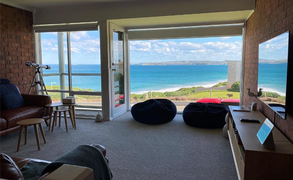 a living room with a view of the ocean at Southern Sands' Beachfront Apartment in Port Elliot