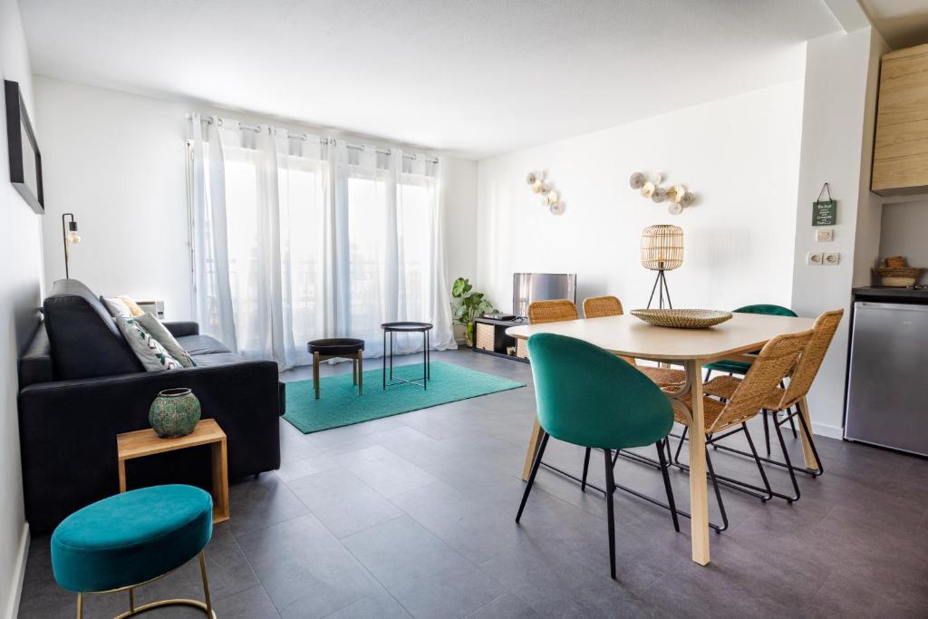 - un salon avec une table et des chaises vertes dans l'établissement Disney Station, 5 minutes Disneyland!, à Chessy