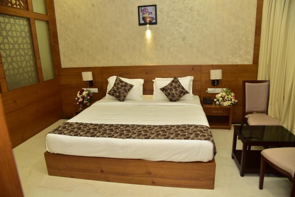 1 dormitorio con 1 cama grande, mesa y escritorio en Fortune Hills, en Palakkad