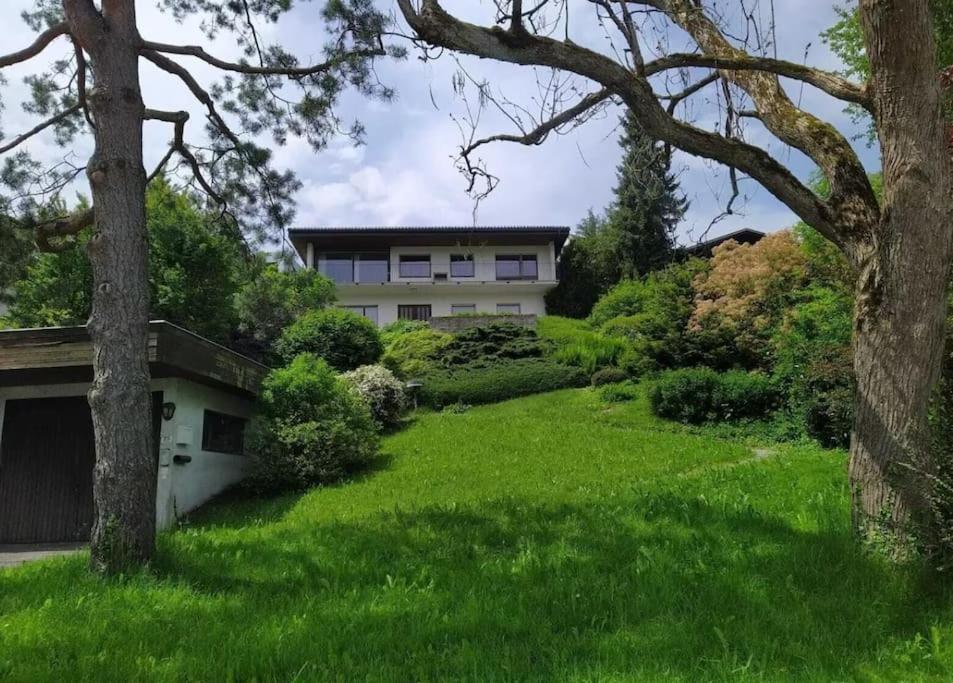een huis op een heuvel met groen gras en bomen bij Ferienwohnung mit Bergblick in Frastanz
