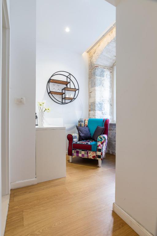 a living room with a chair and a mirror at Apartments & Rooms Grašo in Split