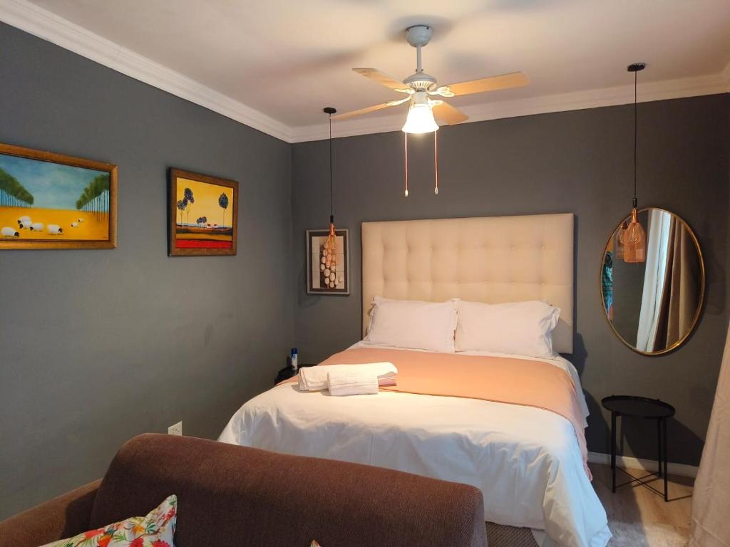 a bedroom with a bed and a ceiling fan at Bird Song in Roodepoort