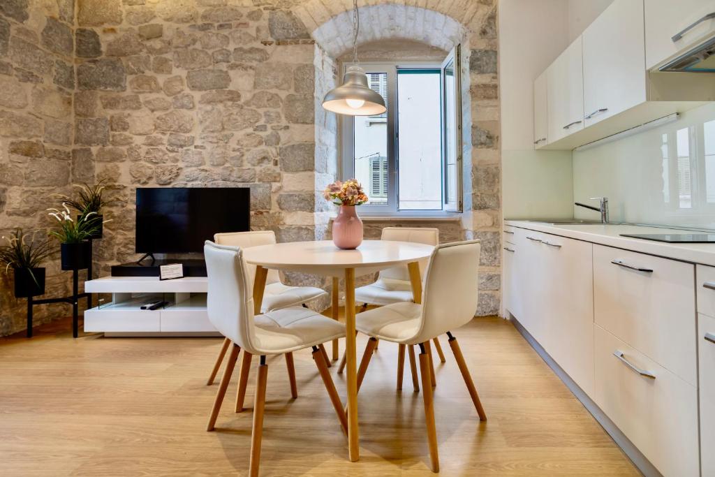 a kitchen and dining room with a table and chairs at Apartments & Rooms Grašo in Split