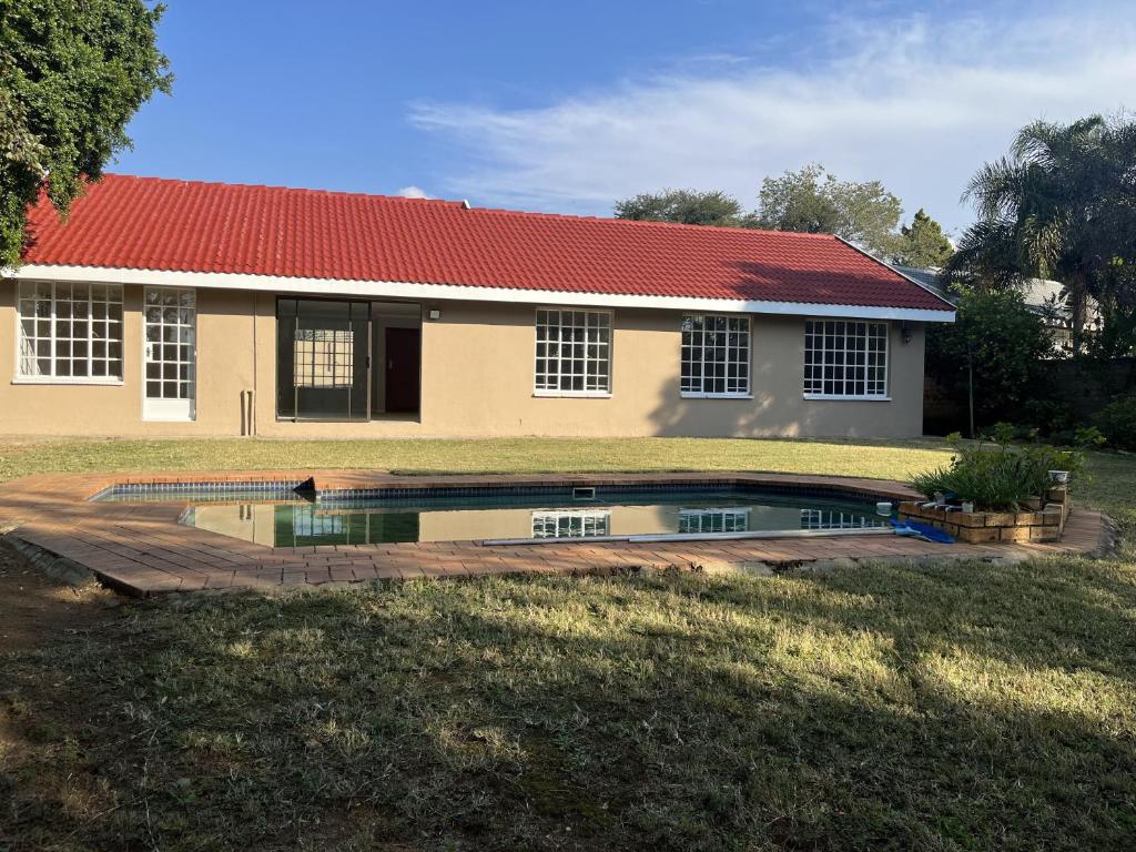 una casa con una piscina di fronte di Kya Sand Guesthouse a Johannesburg