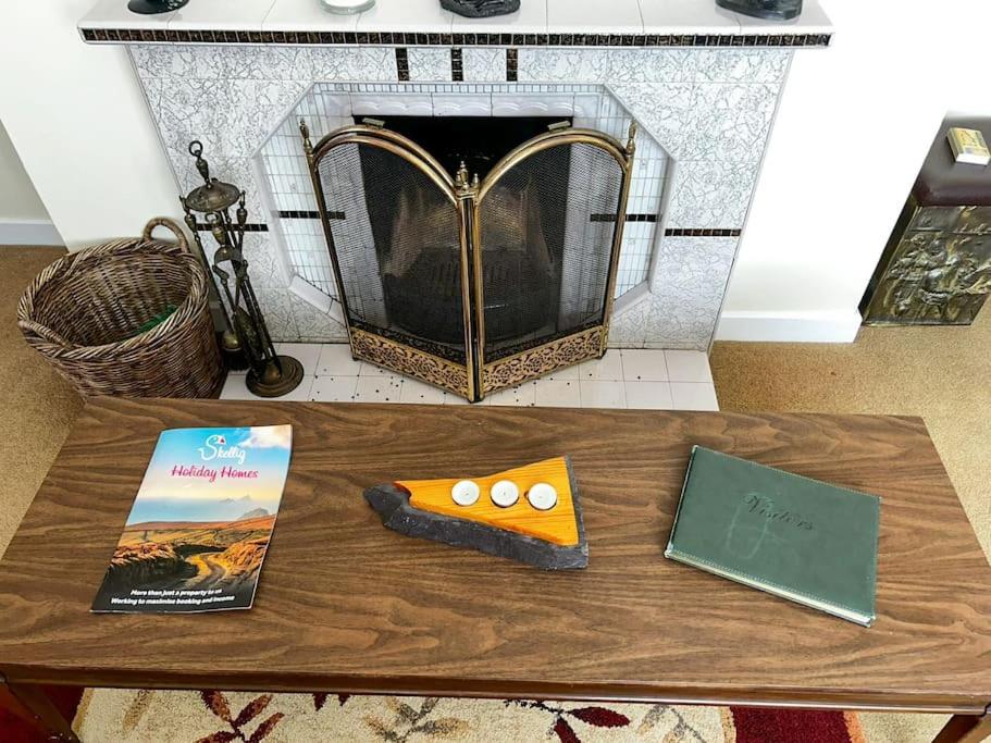 a table with two books on it with a fireplace at Sneem Townhouse in Sneem