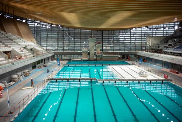 a large indoor swimming pool with blue water at Appartement avec Jardin - La Plaine Saint Denis in Saint-Denis