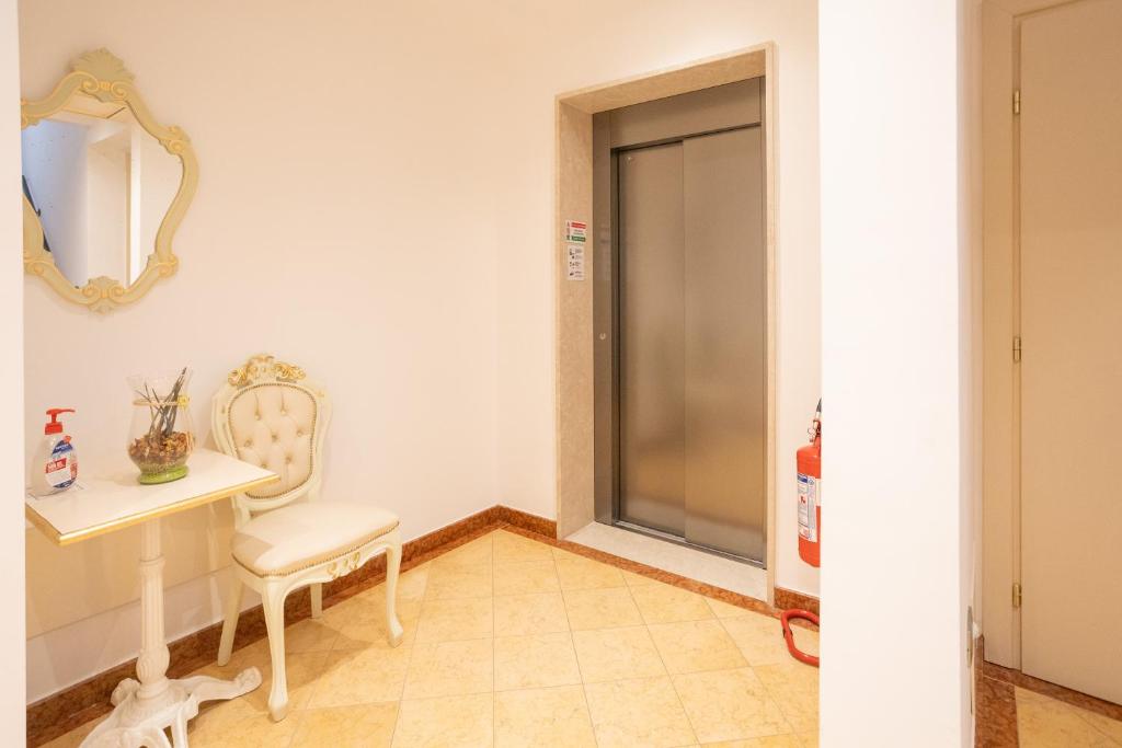 a room with a table and a chair and a mirror at Duomo Boutique Hotel in Chioggia