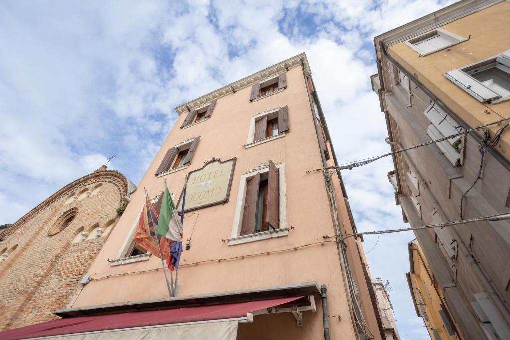 a tall building with a sign on the side of it at Duomo Boutique Hotel in Chioggia