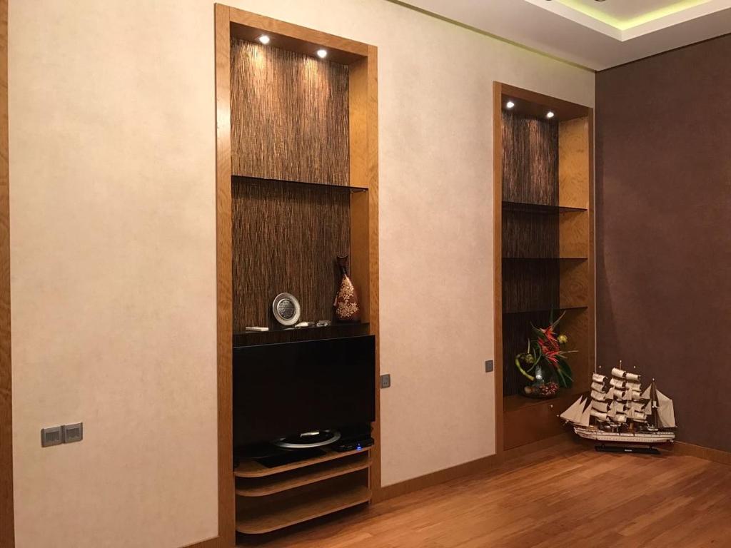 een kamer met een muur met een tv en een deur bij BAKU SAHIL LUX DUPLEX in Baku