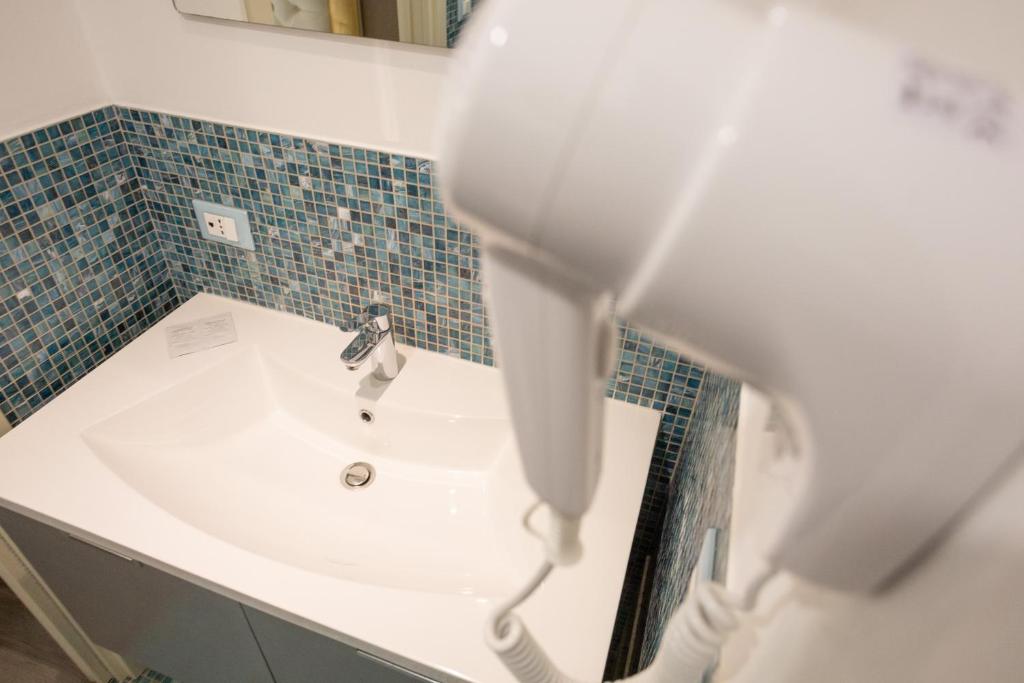 a white sink in a bathroom with blue tiles at Duomo Boutique Hotel in Chioggia