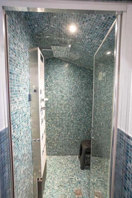 a bathroom with a shower with green tiles at Duomo Boutique Hotel in Chioggia