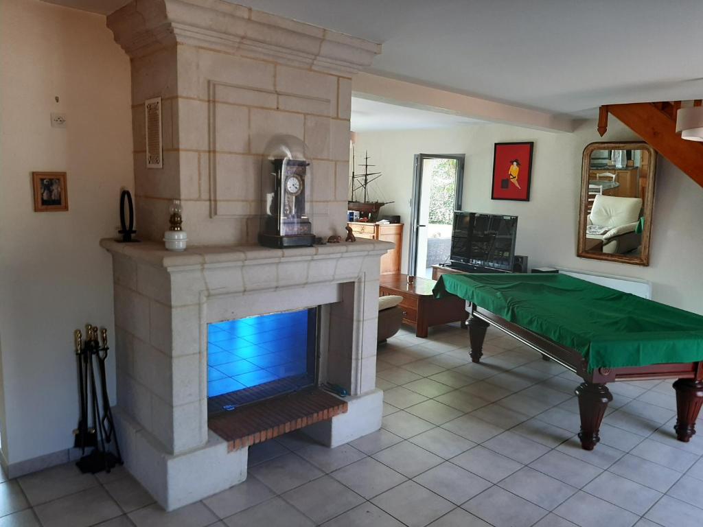 un salon avec une cheminée et une table verte dans l'établissement Villa de charme, à Saumur