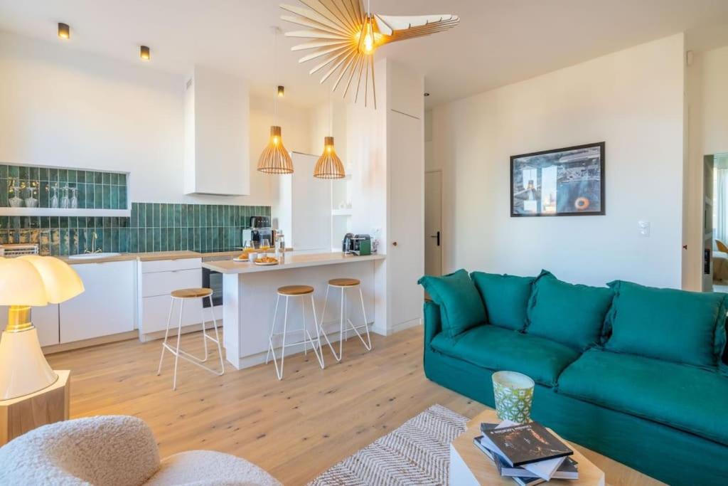 un salon avec un canapé bleu et une cuisine dans l'établissement Le St Victor, garage privé, 1 minute du Vieux Port, à Marseille