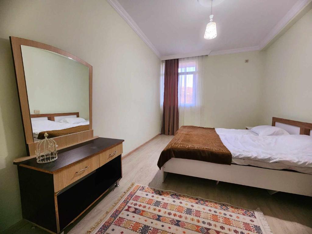1 dormitorio con cama y espejo grande en 53 jincharadze street, en Batumi