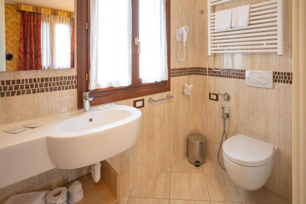 a bathroom with a sink and a toilet at Duomo Boutique Hotel in Chioggia