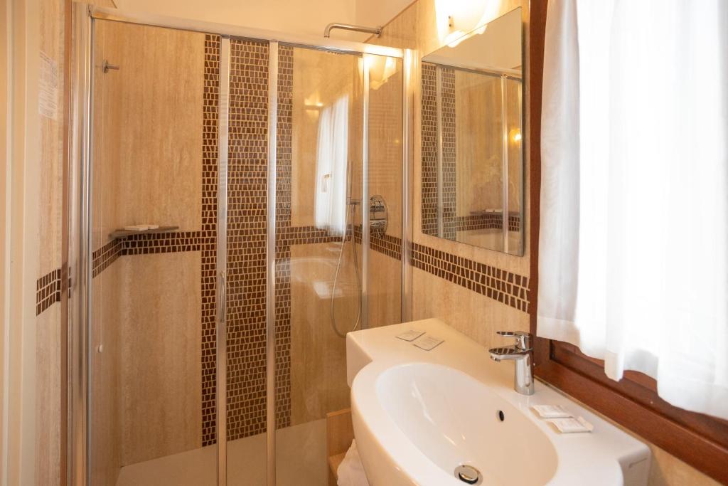 a bathroom with a shower and a sink and a toilet at Duomo Boutique Hotel in Chioggia