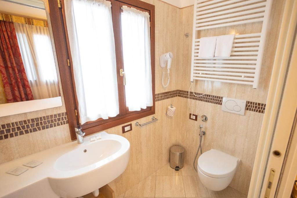 a bathroom with a sink and a toilet at Duomo Boutique Hotel in Chioggia