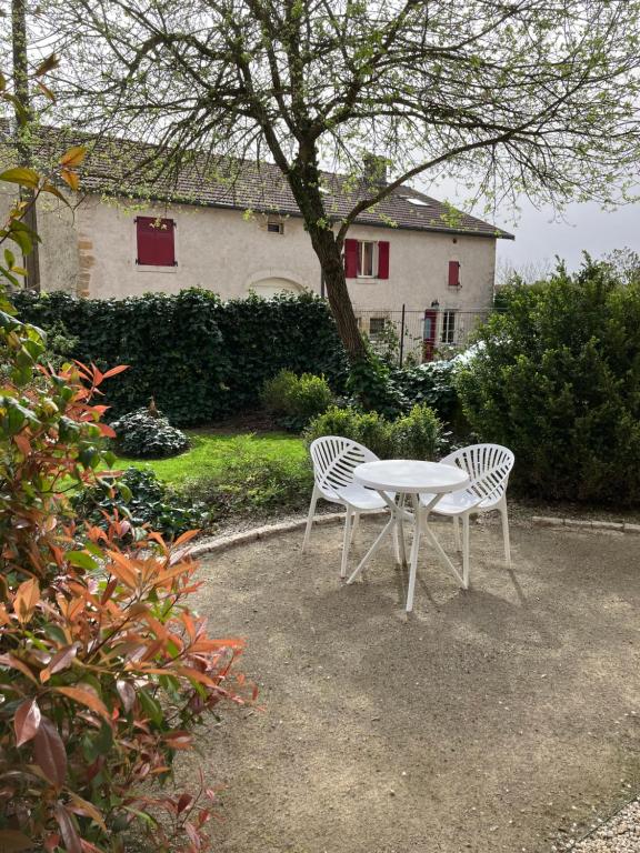 two chairs and a table in front of a house at Le temps retrouvé in Rouvres-la-Chétive