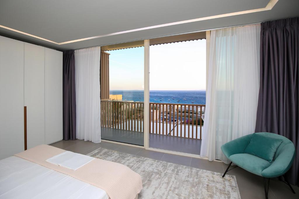 1 dormitorio con 1 cama, 1 silla y balcón en Luxurious 5 Bedroom Beach Villa, en Palasë