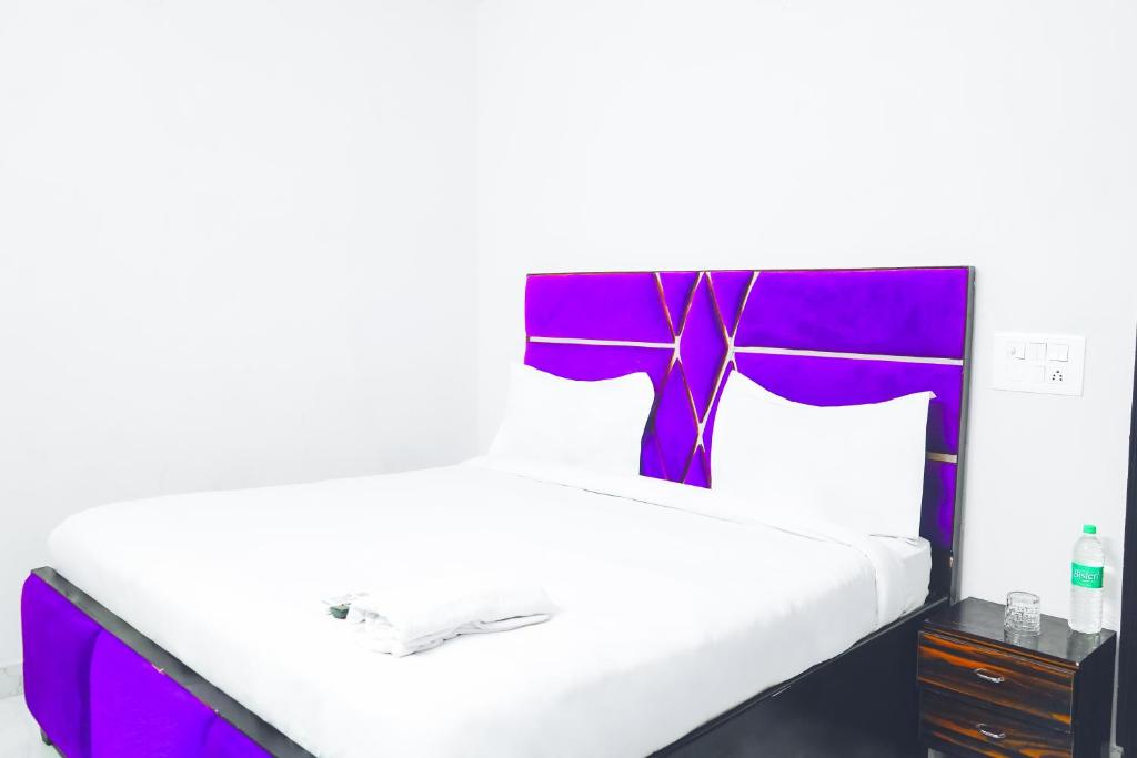 a bed with a purple headboard with a purple bow on it at Hotel Inn sky in New Delhi