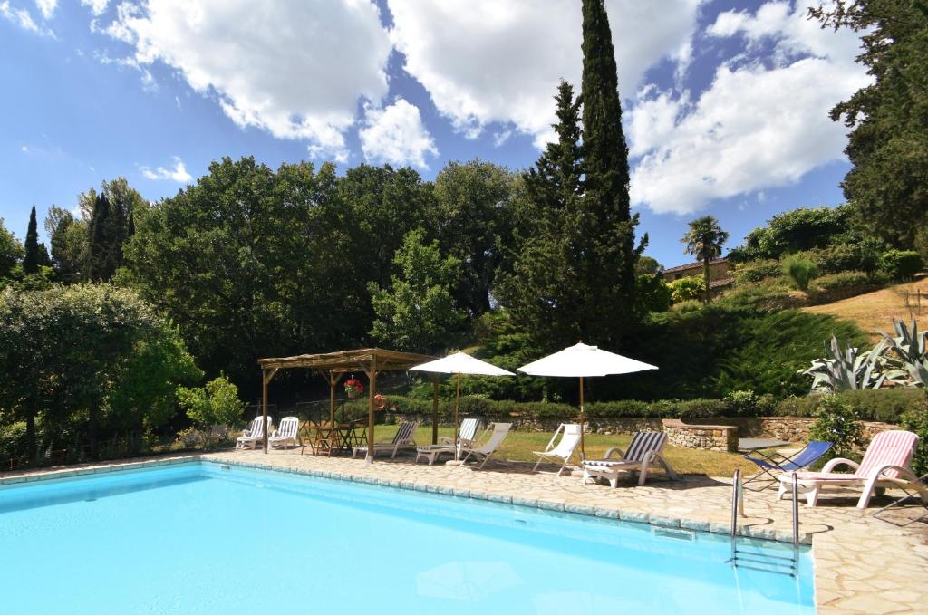 - une piscine avec des chaises longues et des parasols dans l'établissement Villa Siena, à Sienne