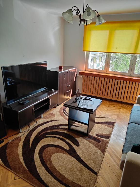 ein Wohnzimmer mit einem TV und einem Couchtisch in der Unterkunft Całe mieszkanie 2 pokojowe na wyłączność centrum Częstochowy, bardzo blisko Jasnej Góry in Częstochowa