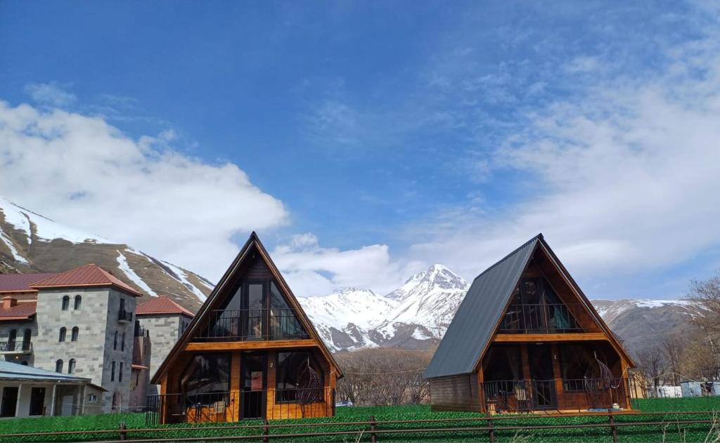 een paar kleine gebouwen met bergen op de achtergrond bij Panorama cottages in Sno in Sno