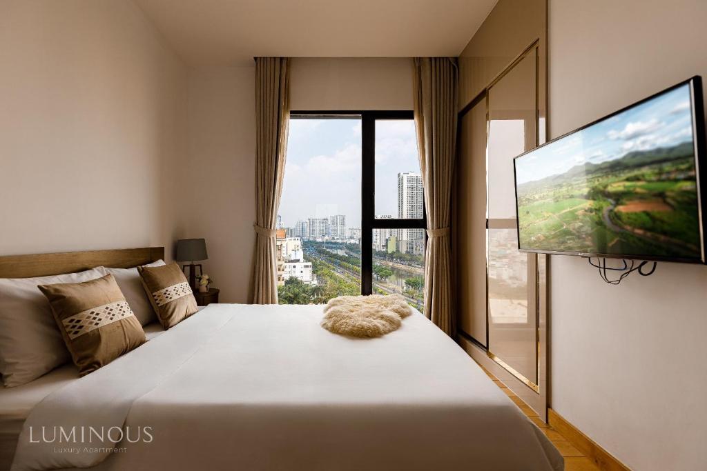 a bedroom with a large bed and a flat screen tv at Exclusive D1mension in District 1 3BR Apartment FreePoolSaunaGym in Ho Chi Minh City