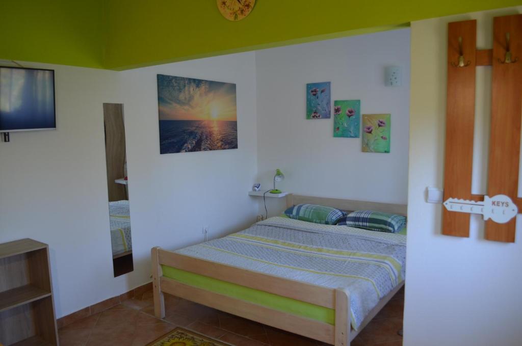 cute colorful studio في بولا: غرفة نوم بسرير وصور على الحائط