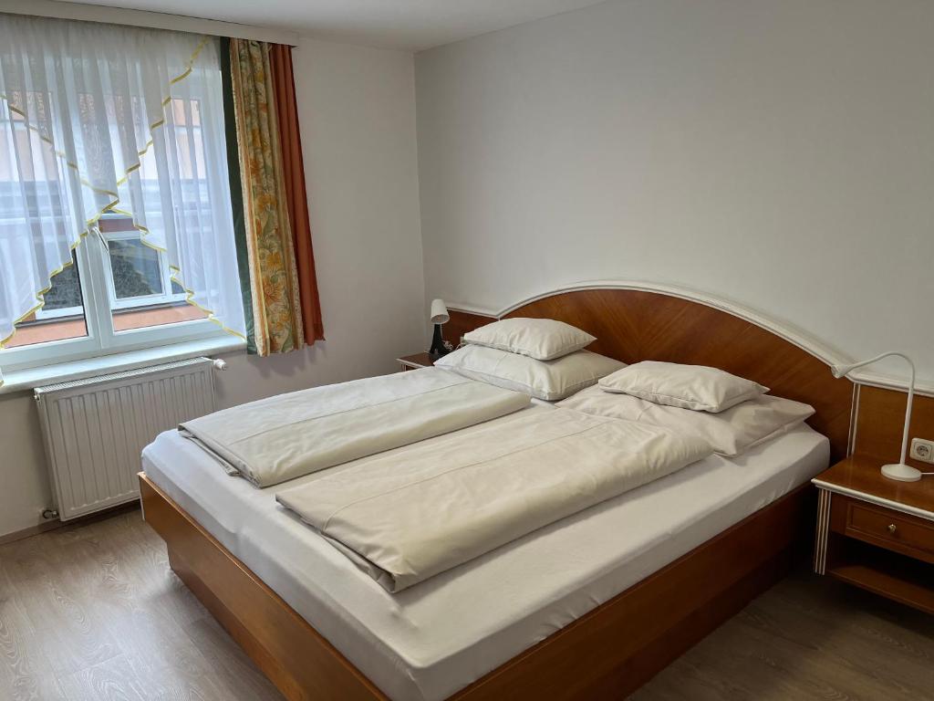 a large bed in a bedroom with a large window at Hotel Altneudörflerhof in Bad Radkersburg