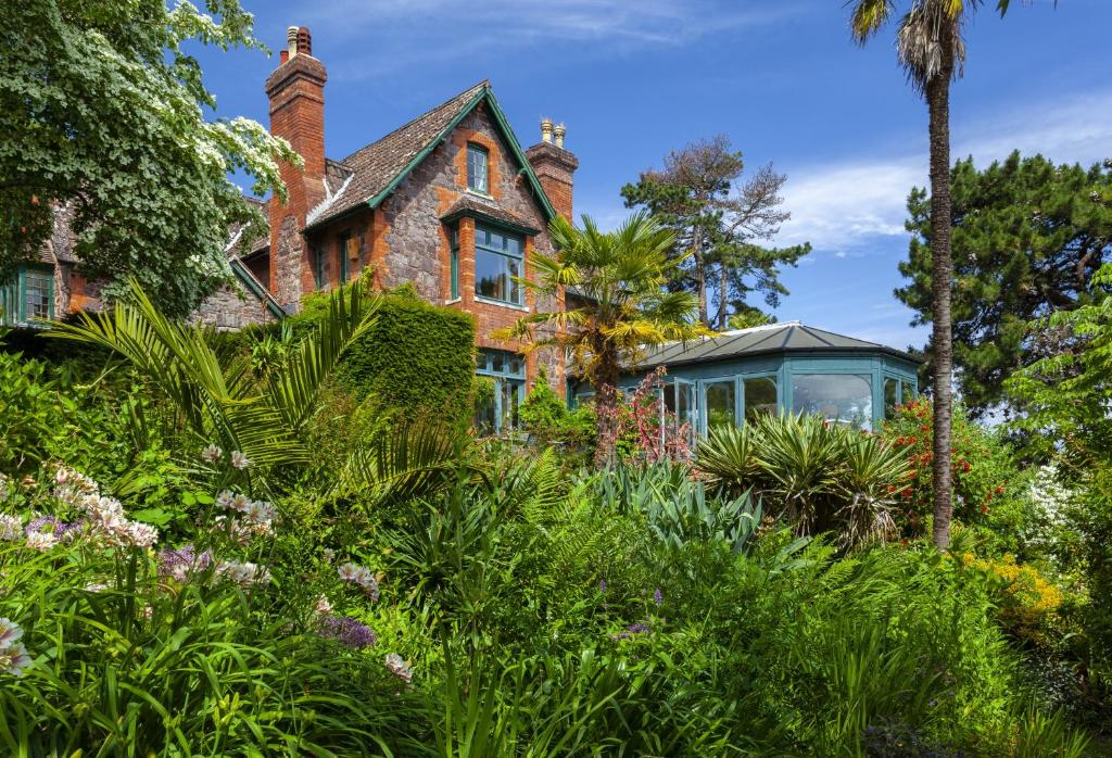 een oud huis met een serre in de tuin bij Chapel Knap Porlock Weir in Porlock