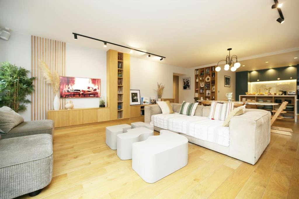 - un salon avec deux canapés blancs et une table dans l'établissement Expérience parisienne en plein coeur du marais, à Paris