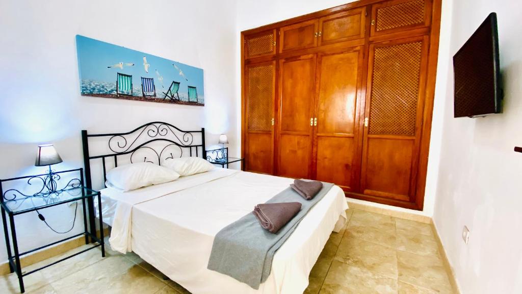 une chambre avec un lit et une armoire en bois dans l'établissement Piso en el centro del Puerto De la Cruz, à Puerto de la Cruz