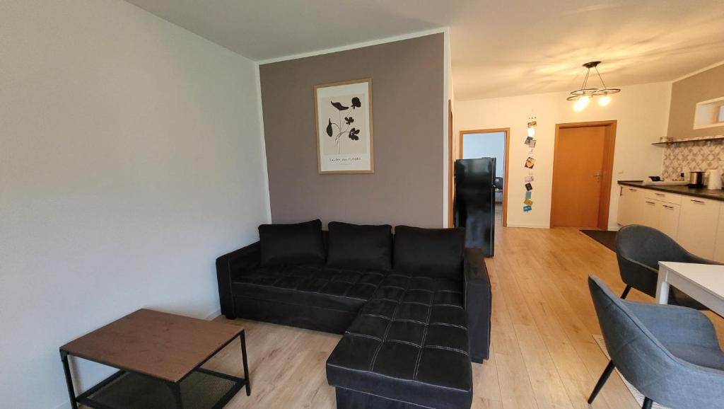 a living room with a black couch and a table at Land.Natur.Erholen. in Wolgast