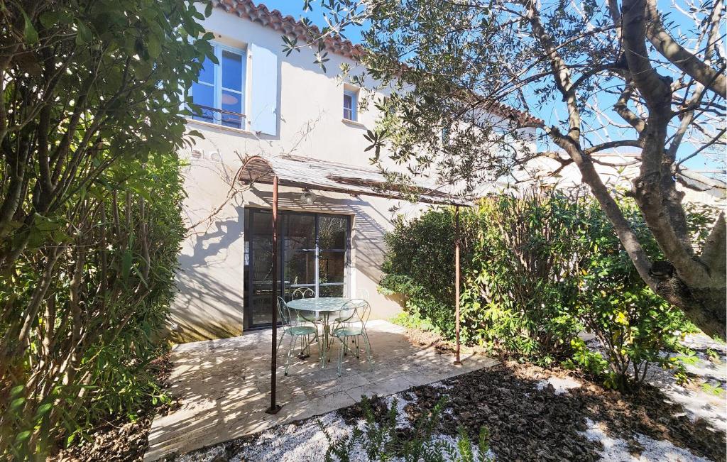 a table and chair sitting on a porch in front of a house at Cozy Home In Saint-Laurent-De-La-Ca With Wifi in Saint-Laurent-de-la-Cabrerisse