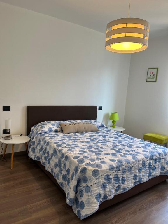 um quarto com uma cama com um edredão azul e branco em THE SUNFLOWER APARTMENT em Ronzo Chienis