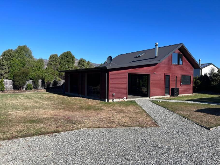 a red barn with a black roof at Heavenly in Hawea in Lake Hāwea