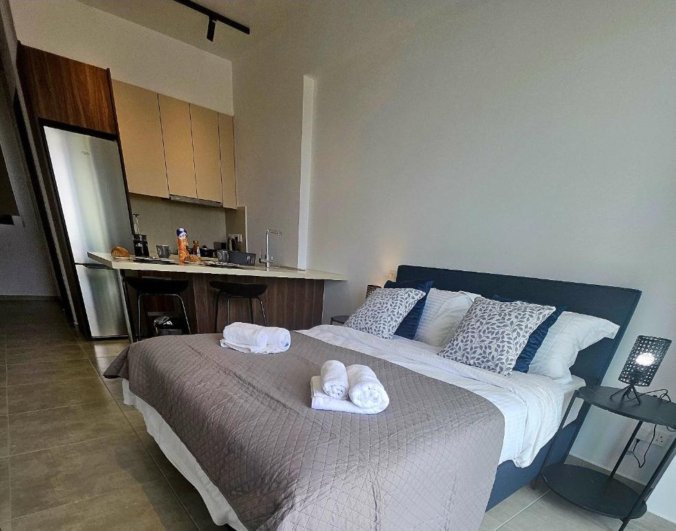 a bedroom with a large bed with towels on it at New, Modern Studio, Universal Residences in Paphos City