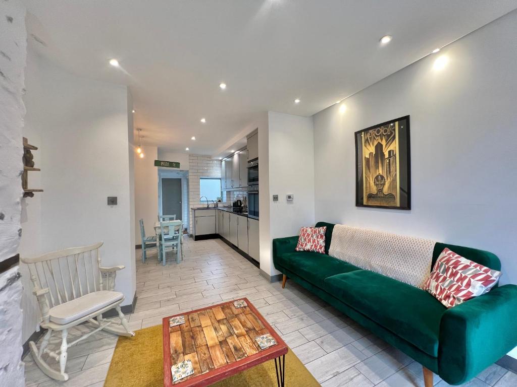 a living room with a green couch and a table at Lovely contemporary ground floor apartment. in Dean