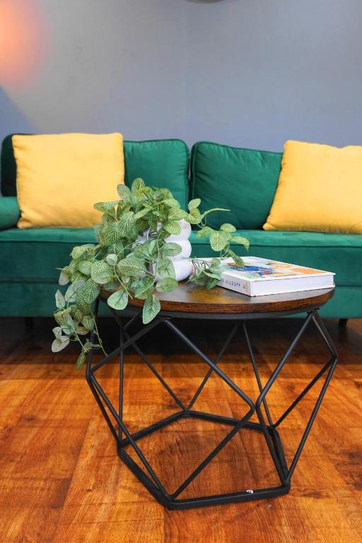 a coffee table in front of a green couch at Modern flat in Luton near LLA with free parking in Luton